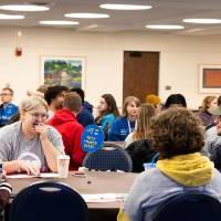 Students chatting amongst themselves at round tables